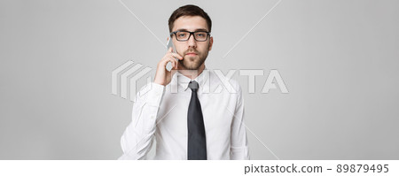 Business Concept - Portrait young handsome angry business man in suit talking on phone looking at camera. White background. 89879495