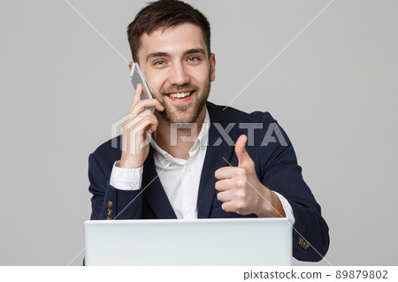 Business Concept - Portrait Handsome Business man showing thump up and smiling confident face in front of his laptop. White Background.Copy Space. Business Concept - Portrait Handsome Business man showing thump up and smiling confident face in front of his laptop. White Background.Copy Space. 89879802