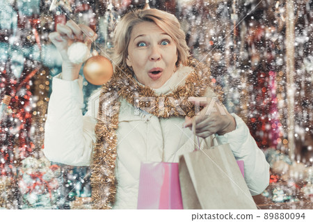 Adult woman is choosing decorations for Christmas tree in the market 89880094