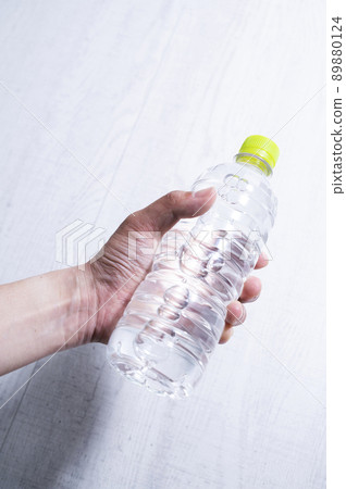 拿著一個塑料瓶的男性手 89880124