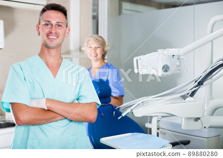 Male dentist in dental office with hands crossed Male dentist in dental office with hands crossed 89880280
