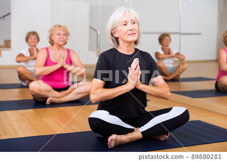 Group of aged ladies sitting in lotus pose Group of aged ladies sitting in lotus pose 89880281