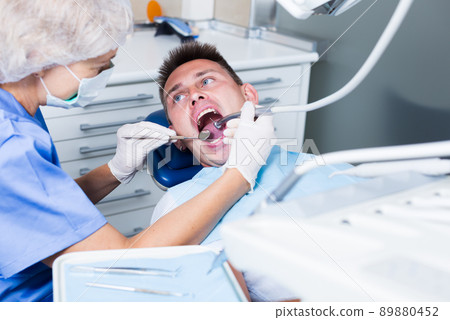 Male patient getting dentist treatment Male patient getting dentist treatment 89880452