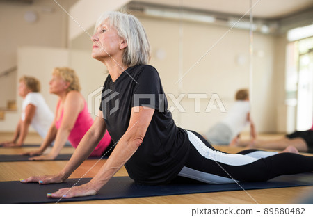 Senior women practicing cobra pose Senior women practicing cobra pose 89880482
