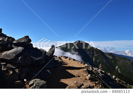 A mountain trail leading from Mt. Yokodoridake to Mt. Jonen, Mt. Jonen surrounded by fog 89885113