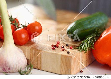 Wooden cutting board with cutted pieces of vegetables, fresh ingredients for salad Wooden cutting board with cutted pieces of vegetables, fresh ingredients for salad 89885582