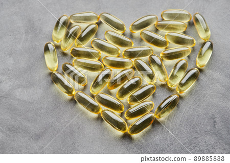 Heart-shaped omega-3 capsules on a gray background. The concept of medicine and healthy living. Top view. 89885888