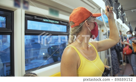 Woman travel caucasian ride at overground train airtrain with wearing protective medical mask. Girl tourist at airtrain with respirator. People mask. 89889152