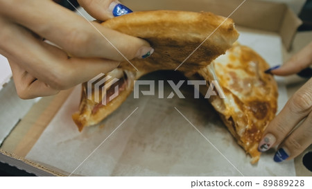 Girl eat pizza cheese four. Close up of young woman mouth greedily eating pizza and chewing in outdoor restaurant. Junk food. Pizza from open box. 89889228