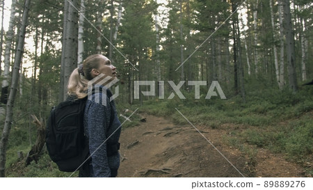 Traveler photographing scenic view in forest. One caucasian woman shooting nice magic look. Girl take photo video on dslr mirrorless camera. 89889276