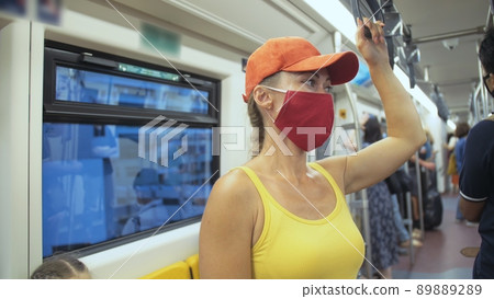 Woman travel caucasian ride at overground train airtrain with wearing protective medical mask. Girl tourist at airtrain with respirator. People mask. 89889289