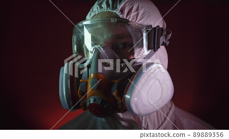 Man in protective costume suit, gas protect medical spray paint mask. Doctor in respirator. Concept health virus coronavirus epidemic. 89889356