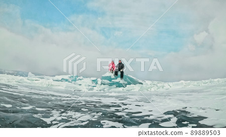 Couple has fun during winter walk against background of ice of f 89889503