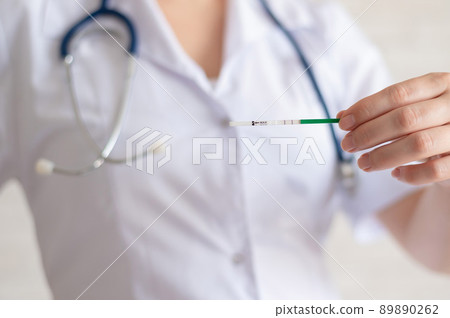 The doctor keeps a positive pregnancy test. The faceless gynecologist recommends the use of rapid pregnancy tests. The doctor keeps a positive pregnancy test. The faceless gynecologist recommends the use of rapid pregnancy tests. 89890262