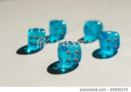 Five transparent blue dice on a white table. Five transparent blue dice on a white table. 89890270