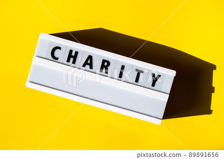 Lightbox with text CHARITY. Motivational Words Quotes Concept. Colorful yellow background. Minimalistic creative concept. Lightbox with text CHARITY. Motivational Words Quotes Concept. Colorful yellow background. Minimalistic creative concept. 89891656