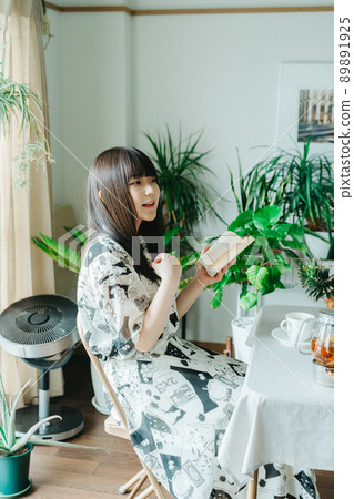 一個年輕女子在她的房間裡享受閱讀 89891925