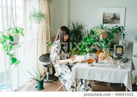 一個年輕女子在她的房間裡享受閱讀 一個年輕女子在她的房間裡享受閱讀 89891932