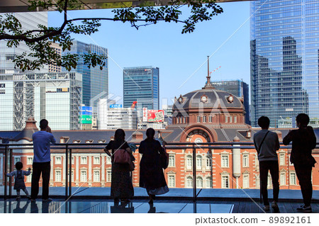 Tokyo Station surrounded by fresh green trees and skyscrapers in the warm spring sunshine 89892161