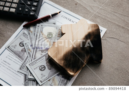A dollar banknotes and a burn house on an insurance contract. Destruction of a home and insurance services 89894418