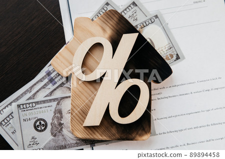 Lost of savings and destruction of real estate concept. Percentage symbol and burnt house on an insurance contract 89894458