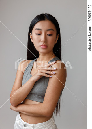 Asian young woman in crop top standing in studio Asian young woman in crop top standing in studio 89895452
