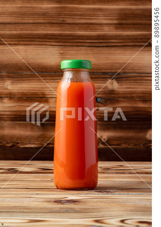 Glass of tomato juice on wooden table Glass of tomato juice on wooden table 89895456