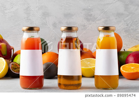 Various fruits and freshly squeezed fruits juice in bottle on gray background 89895474