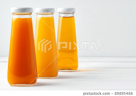 Glass bottles of different juices on white background 89895488