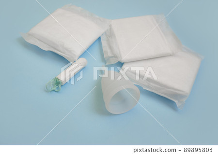 Pad, menstrual cup, tampon on a blue background. The view is flat. Concept of critical days, menstruation. Pad, menstrual cup, tampon on a blue background. The view is flat. Concept of critical days, menstruation. 89895803