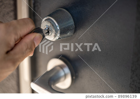 將鑰匙插入鑰匙孔的手 將鑰匙插入鑰匙孔的手 89896139