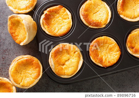 Queijadas Portuguese Custard Cupcakes close-up in a baking dish. Horizontal top view Queijadas Portuguese Custard Cupcakes close-up in a baking dish. Horizontal top view 89896716