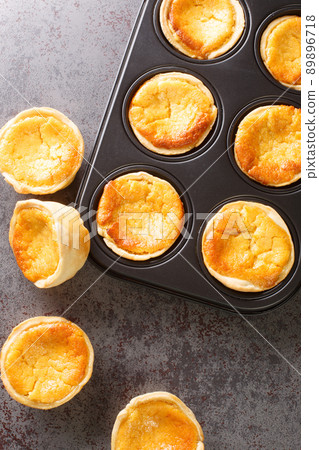 Tarts Queijadas with custard close-up in a baking dish. vertical top view Tarts Queijadas with custard close-up in a baking dish. vertical top view 89896718