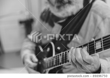 Close-up hands and electric guitar. Cropped monochrome portrait of man, rock musician playing guitar isolated on light background. Concept of music, style, art Close-up hands and electric guitar. Cropped monochrome portrait of man, rock musician playing guitar isolated on light background. Concept of music, style, art 89896750