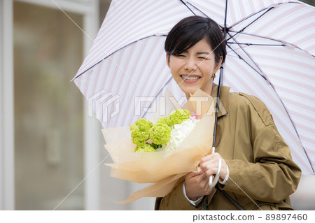 一個女人在雨天帶著繡球花散步 89897460