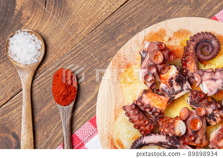 Pulpo a la gallega,galician octopus with potatoes paprika, salt and olive oil. typical Spanish Galician tapa on traditional wooden plate. Tipical Spanish tapa concept. Pulpo a la gallega,galician octopus with potatoes paprika, salt and olive oil. typical Spanish Galician tapa on traditional wooden plate. Tipical Spanish tapa concept. 89898934