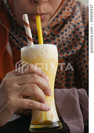 young women drinking banana milk shake at cafe young women drinking banana milk shake at cafe 89900437