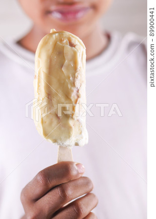 young men eating vanila flavor ice cream in a container  89900441