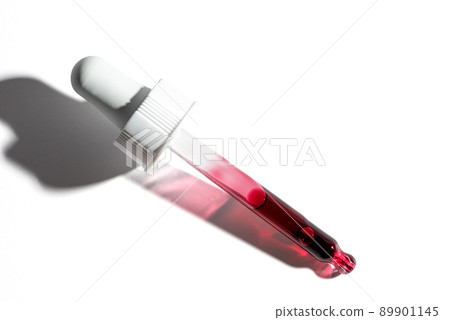 Liquid red oil serum drop in pipette isolated on white background. Retinol, aha acid, collagen skincare fluid, close up photo with shallow depth of field. Transparent crimson essence in dropper Liquid red oil serum drop in pipette isolated on white background. Retinol, aha acid, collagen skincare fluid, close up photo with shallow depth of field. Transparent crimson essence in dropper 89901145