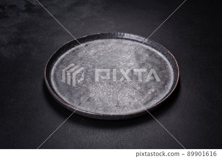 Black plate on a black background. Flat lay, top view, copy space Black plate on a black background. Flat lay, top view, copy space 89901616