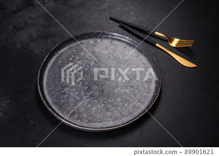 Black plate on a black background. Flat lay, top view, copy space 89901621