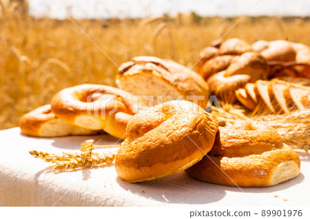 lot of different flavored bread, wheat, rye, on the table in the field outside 89901976