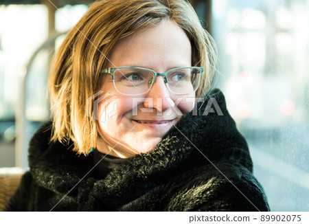 Brussels city center, Belgium - Attractive thirty year old woman looking out of the window of a local train with a furry coat Brussels city center, Belgium - Attractive thirty year old woman looking out of the window of a local train with a furry coat 89902075