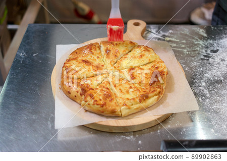Sliced cheese pizza in a rastaurant kitchen. 89902863