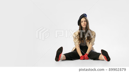 Fashion shot. Portrait of beautiful young girl, teen in retro style clothes posing at white studio background. Concept of art, beuty, youth, vintage Fashion shot. Portrait of beautiful young girl, teen in retro style clothes posing at white studio background. Concept of art, beuty, youth, vintage 89902879