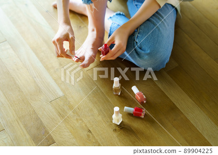 一個女人在腳趾上塗凝膠指甲 89904225