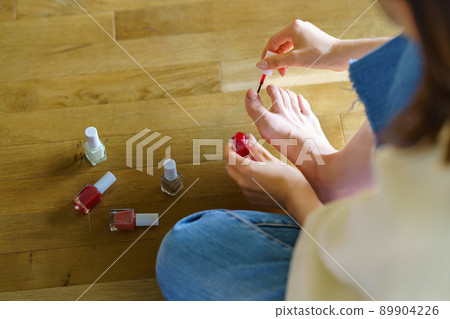 一個女人在腳趾上塗凝膠指甲 一個女人在腳趾上塗凝膠指甲 89904226
