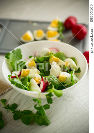 Fresh spring salad with fresh lettuce leaves, radishes, boiled eggs in a bowl Fresh spring salad with fresh lettuce leaves, radishes, boiled eggs in a bowl 89905109