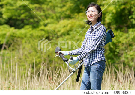 中年婦女用割草機割草 89906065