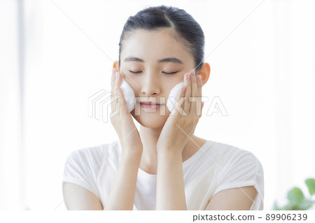 A young woman cleansing face A young woman cleansing face 89906239